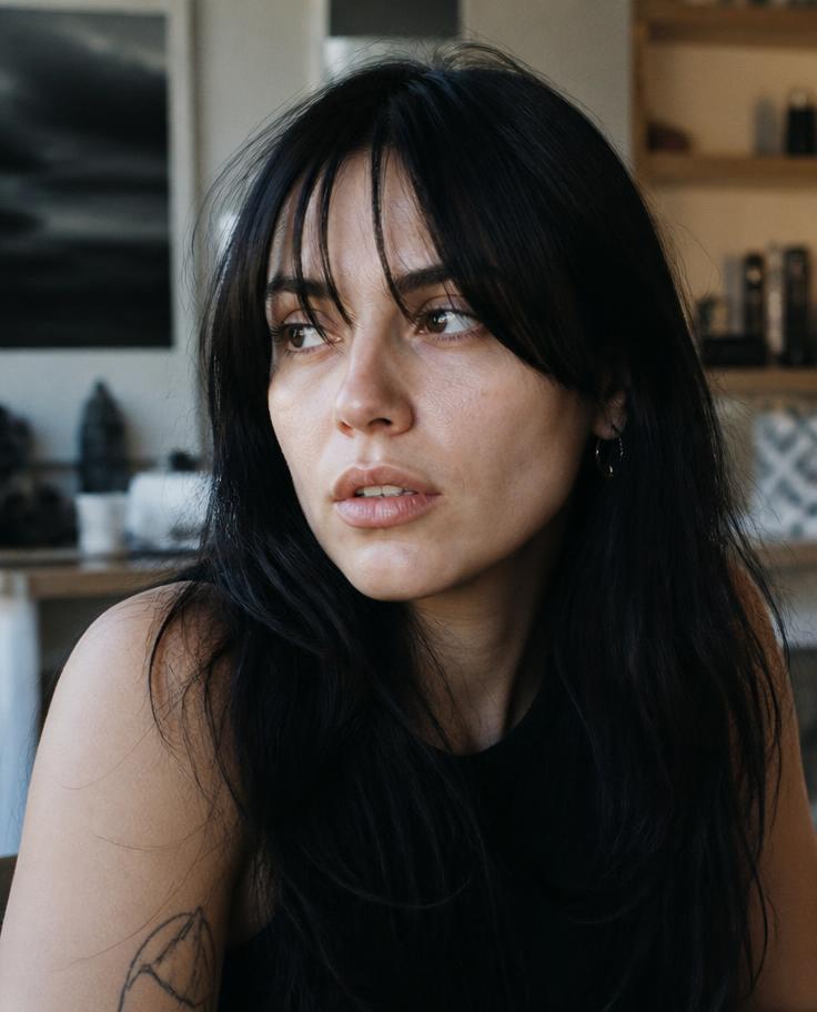 Model with sleek black hair and curtain bangs