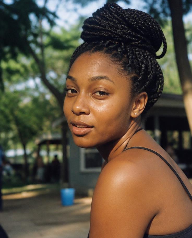 Model with box braids in a high bun